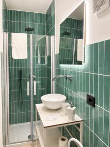 a green tiled bathroom with a sink and a shower at IL Corso in Torre del Greco