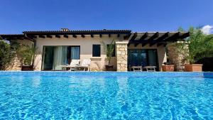 a villa with a swimming pool in front of a house at Luxury villas and golf GV6 in Balchik