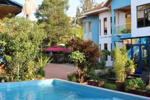 a pool in front of a house with trees at Umusambi B&B in Kigali