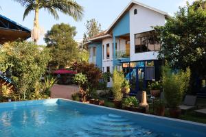 a house with a swimming pool in front of a house at Umusambi B&B in Kigali