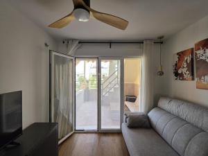 a living room with a couch and a ceiling fan at ÁTICO TERESA BORA PALM, PISCINA PRIVADA CLIMATIZABLE 250m playa in Vera
