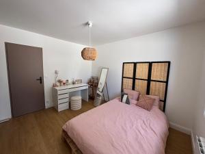 a bedroom with a pink bed and a desk at Maison au calme avec piscine et jardin in BOD