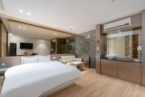 a bedroom with a large white bed and a bathroom at Hotel Airport in Busan