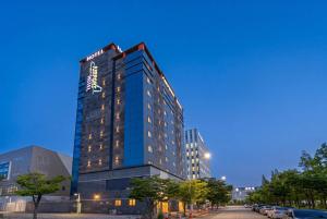 a tall blue building with a sign on it at Hotel Airport in Busan