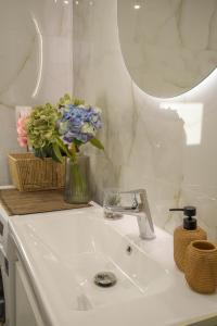 a bathroom sink with a vase of flowers on it at Grimihome 2 in Filiatra +17 photos