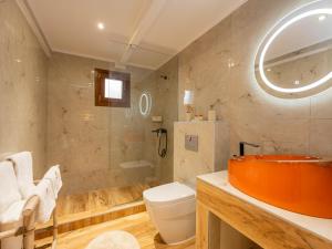 a bathroom with an orange sink and a toilet at Green Olive Luxury Villas in Paliouri