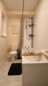 a bathroom with a tub and a toilet and a sink at Cloud Quarters 4 in Huddersfield