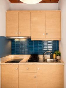 a kitchen with wooden cabinets and a sink at Thelxis Room in Nydri
