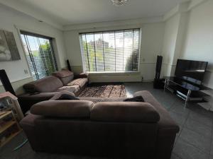 a living room with two couches and a flat screen tv at SB villa house in Vlissingen