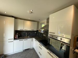 a kitchen with white cabinets and black counter tops at SB villa house in Vlissingen +14 photos