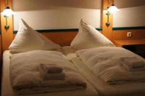 a bed with two towels and two pillows on it at Hansens Zimmervermietung in Handewitt