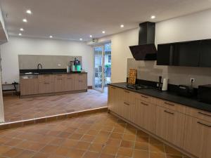 a large kitchen with wooden cabinets and a tile floor at Hansens Zimmervermietung in Handewitt