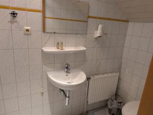 a white bathroom with a sink and a mirror at Hansens Zimmervermietung in Handewitt