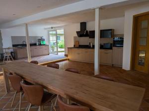 a large kitchen with a wooden table and chairs at Hansens Zimmervermietung in Handewitt +3 photos