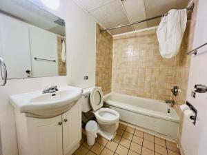 a bathroom with a sink and a toilet and a tub at Midtown Inn SSK in Saskatoon