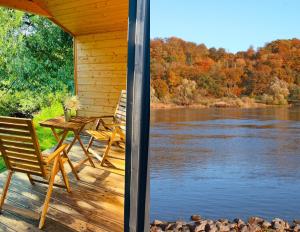 a porch of a cabin with a table and chairs at 206 The tiny "Office" House in Bleckede