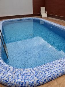 a large swimming pool with a chair in a room at Green house eco hotel Samarkand in Samarkand +25 photos