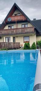 a house with a swimming pool in front of a house at Willa Maciejka - Domek Narciarski in Trybsz