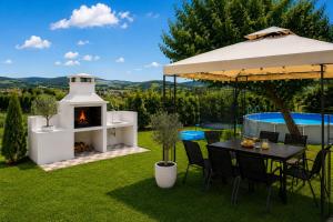 a backyard with a fire pit and a table and chairs with a fireplace at Villa Conceptt casa in Jasenak