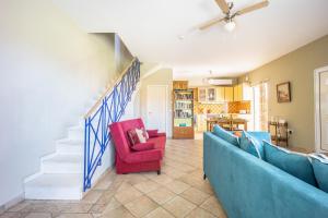 a living room with a blue couch and a red chair at Artemis Breeze in Artemida