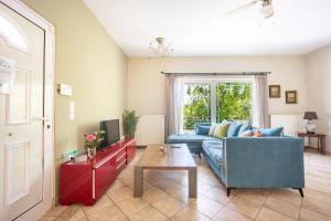 a living room with a blue couch and a table at Artemis Breeze in Artemida