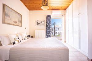 a bedroom with a large bed and a large window at Artemis Breeze in Artemida