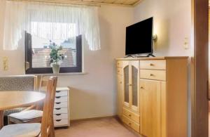 a living room with a television on a dresser at Gemütliche Wohnung am Main 1 in Gemünden