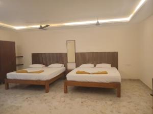 two beds in a room with two beds sidx sidx sidx sidx at SANTHOSH RESIDENCy in Chengalpattu