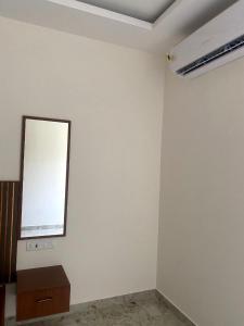 a room with a white wall with a mirror on it at SANTHOSH RESIDENCy in Chengalpattu