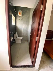 a bathroom with a toilet and a toilet bowl at SANTHOSH RESIDENCy in Chengalpattu