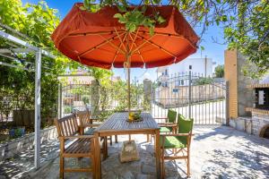 a table and chairs under an umbrella on a patio at Artemis Breeze in Artemida