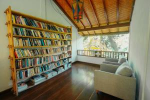 a living room with two book shelves filled with books at Uns Hotel - Bali in Legian