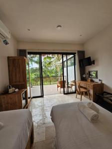a hotel room with two beds and a desk and a desk at Bali View Ubud Hotel in Ubud