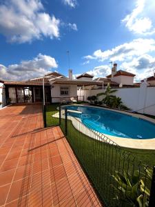 a swimming pool in the backyard of a house at Chalet Matalascañas in Matalascañas