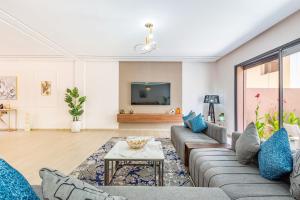 a living room with a couch and a tv at Villa Horizon Premium - Private Pool - Fully Renovated - Marrakech in Marrakesh