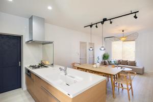 a kitchen and living room with a sink and a table at インギャーラクシー in Miyakojima
