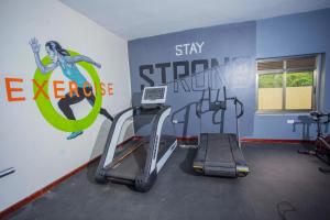 ein Fitnessstudio mit einem Laufband und einem Schild an der Wand in der Unterkunft FortBreeze Hotel in Fort Portal + 1 Foto