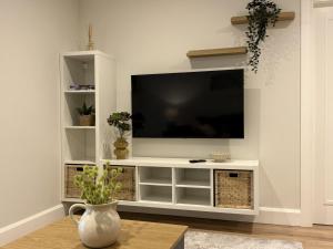 a white entertainment center with a flat screen tv at Apartment 299 - Clifden in Clifden