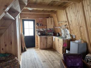 a kitchen with wooden walls and a door in a room at Cloudtop House - Gomismta in Gomi