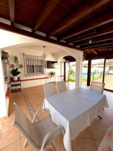a dining room with a white table and chairs at Chalet Matalascañas in Matalascañas