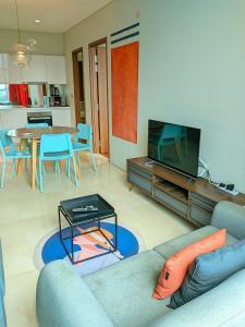 a living room with a couch and a tv and a table at Sky Suites KLCC Kuala Lumpur LB in Kuala Lumpur