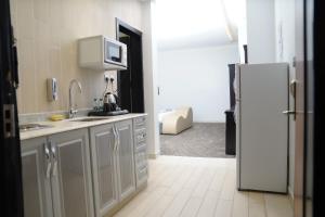 a kitchen with a sink and a refrigerator at Pherbion Hotel Apartment Abha in Abha