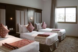 a hotel room with two beds and a window at Pherbion Hotel Apartment Abha in Abha +39 photos