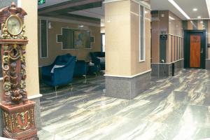 a lobby with chairs and a clock in a building at Pherbion Hotel Apartment Abha in Abha