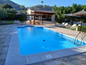 a large blue swimming pool in front of a house at Villa enseñat ETV04085 in Pollença