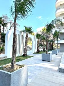 a courtyard with palm trees in front of a building at Rezidenca Onda in Lezhë