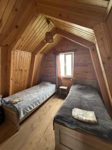 a room with two beds in a wooden cabin at Cloudtop House - Gomismta in Gomi