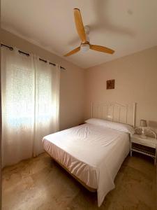 a bedroom with a bed and a ceiling fan at Chalet Matalascañas in Matalascañas
