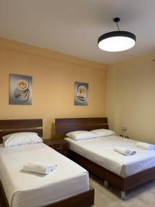 a room with two beds and a light at Shengjin Central Apartments in Shëngjin