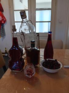 two bottles and a bowl of berries on a table at "Poetsko ćoše" Nikole Tesle 86 in Morović